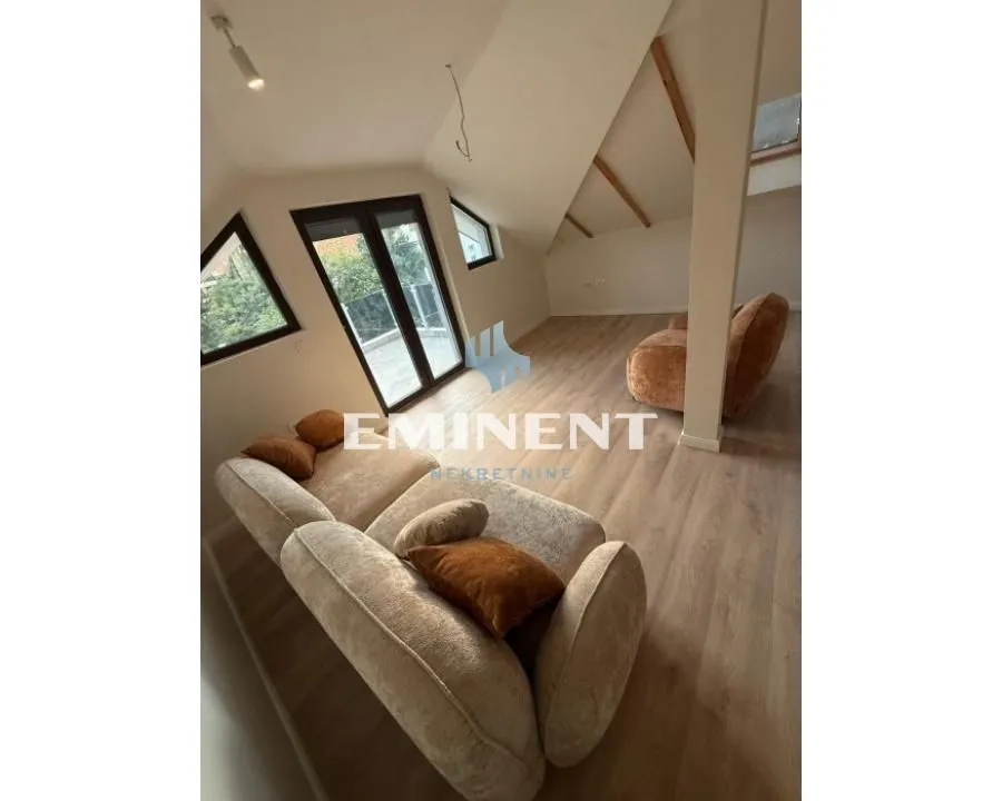 Attic living room with sofa set and roof windows.