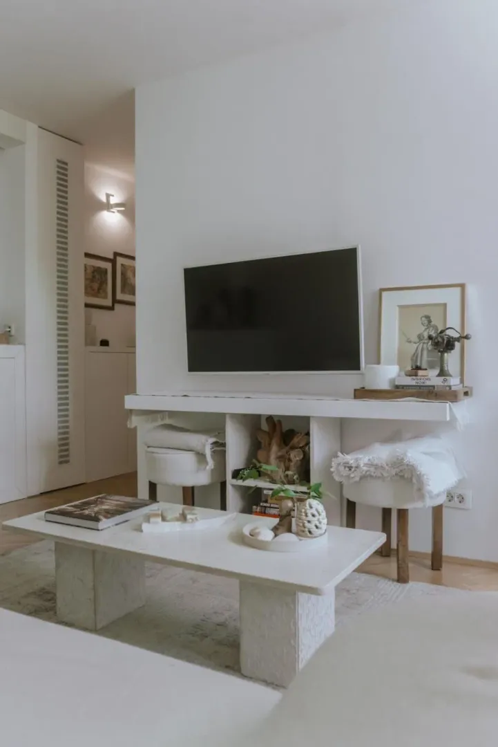 Dnevna soba sa TV-om, stočićem i dekorativnim elementima.