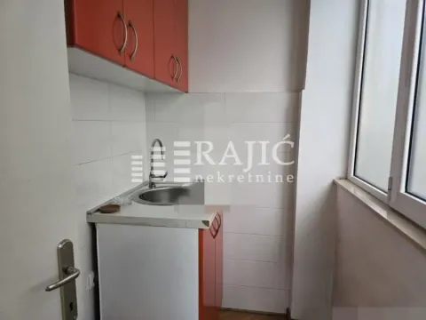 Smaller kitchen with cabinets and a sink next to the window. - image 6