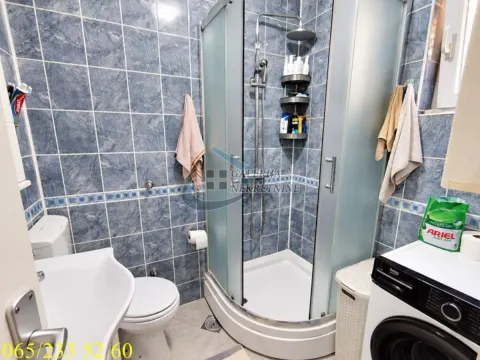 Kupatilo obloženo pločicama sa tuš kabinom, umivaonikom i veš mašinom. - image 11