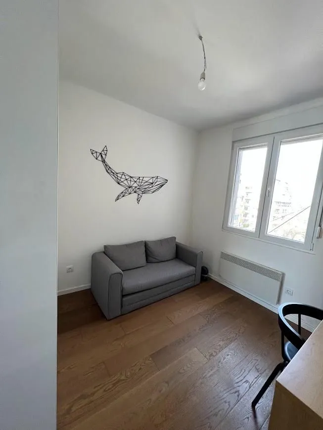 Smaller living room with a grey sofa and wooden flooring.