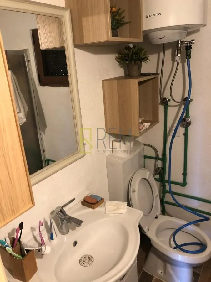 Manje kupatilo sa umivaonikom, WC šoljom i bojlerom.