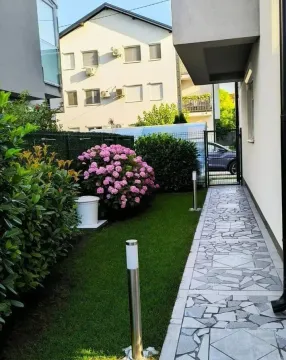 Uređeno dvorište sa stazom, travnjakom i ukrasnim biljem. - image 19