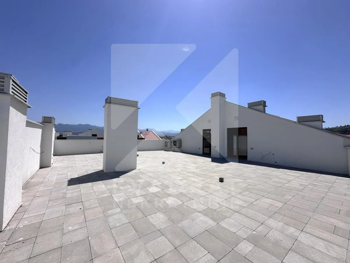Large tiled terrace on the roof of the building.