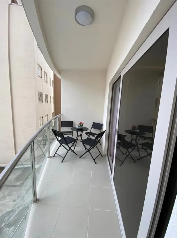 Manji namješteni balkon sa stolom i stolicama.