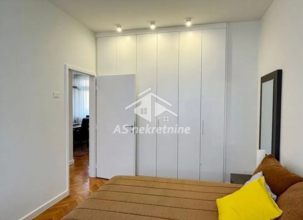 Bedroom with a large built-in wardrobe and a double bed.