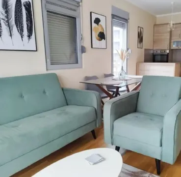 Living room with sofa and dining area in the background. - image 2