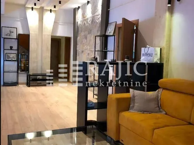 Living room with a sofa and wooden flooring.