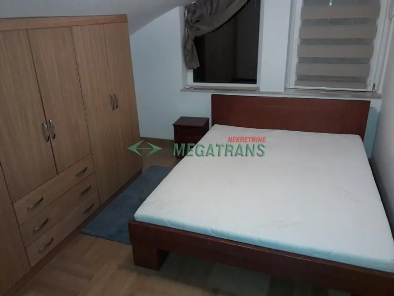 Furnished bedroom with a double bed, wardrobe, and nightstand.