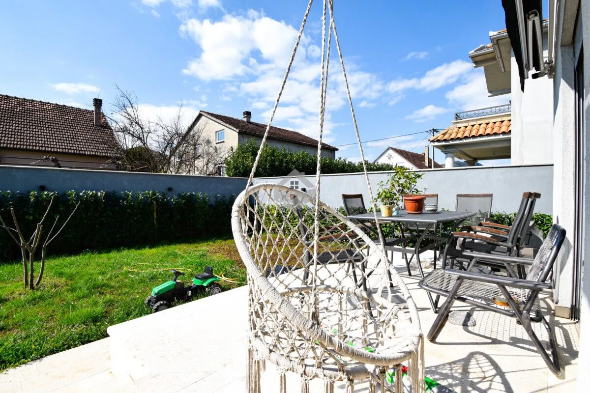 Yard with a terrace, garden furniture, and a hanging chair.