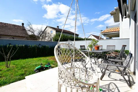 Yard with a terrace, garden furniture, and a hanging chair. - image 11