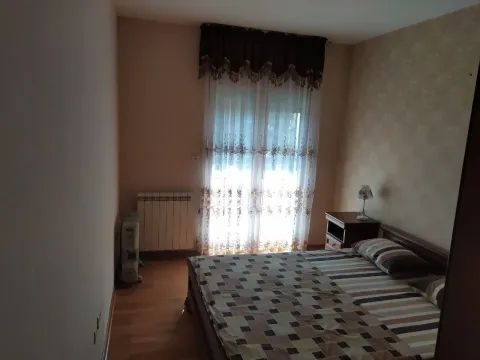 Bedroom with a double bed and a curtained window. - image 9