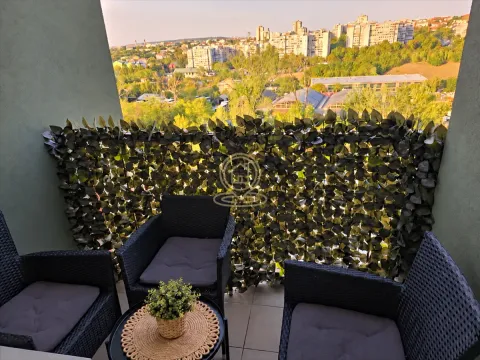 Namešten balkon sa garniturom za sedenje i pogledom na grad. - image 11