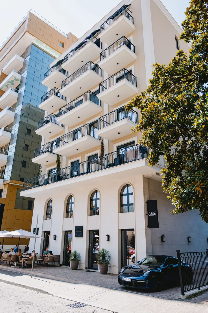 Exterior view of a modern multi-family building with balconies and ground-floor commercial space.