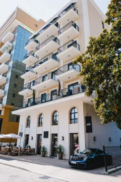Exterior view of a modern multi-family building with balconies and ground-floor commercial space. - image 7