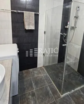 Modern bathroom with a shower cabin and white tiles. - image 10
