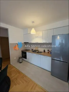 Moderna kuhinja sa belim elementima i velikim frižiderom. - image 7