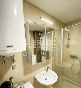 Smaller bathroom with a shower cabin, washbasin, and water heater. - image 6