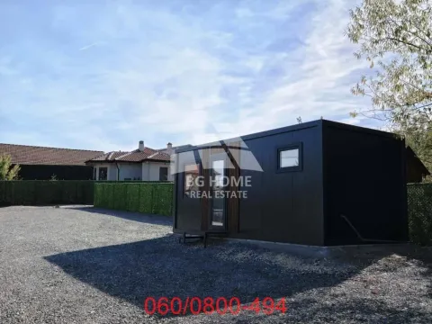 Pogled na dvorište sa manjom montažnom kućicom i popločanim prostorom. - image 2