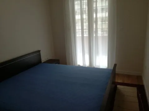 Bedroom with a double bed and a window with white curtains. - image 9