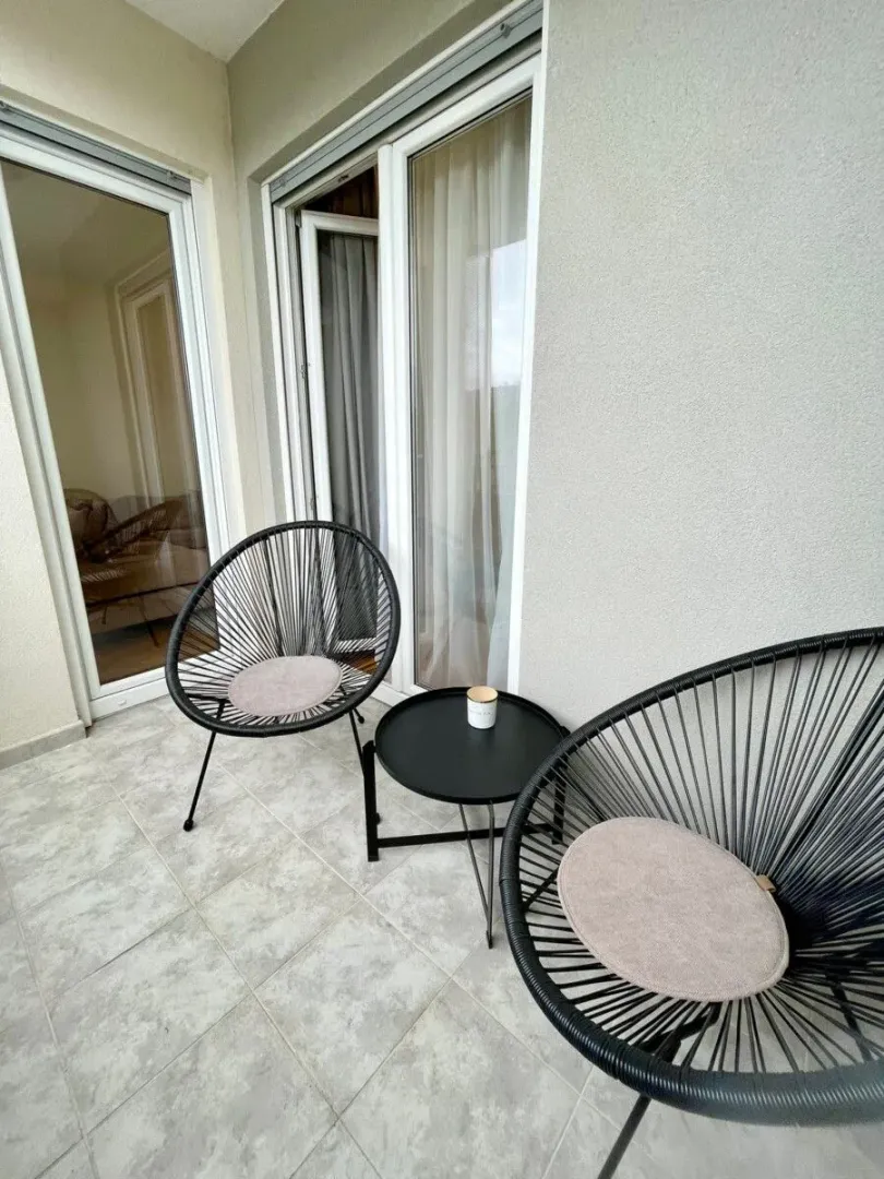 Small furnished balcony space with two chairs and a small table.