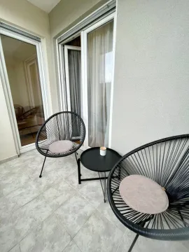 Small furnished balcony space with two chairs and a small table. - image 10