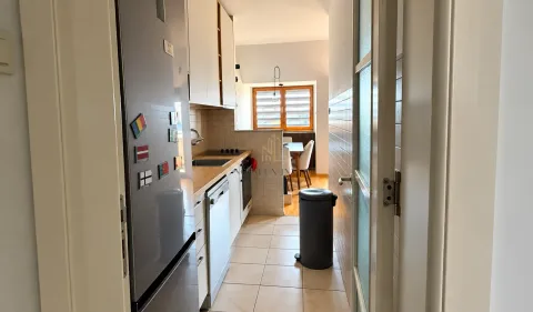 View of a narrow kitchen with a refrigerator and built-in units. - image 3