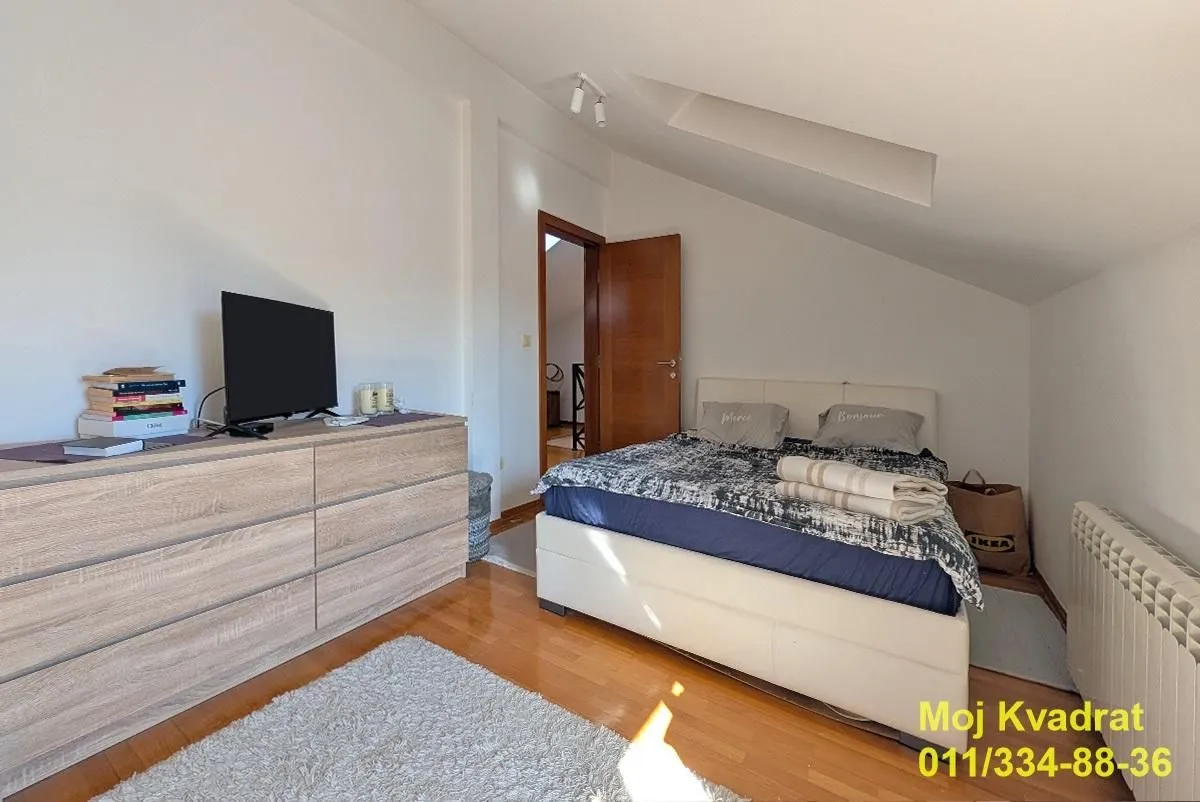 Furnished bedroom with a double bed and a chest of drawers.