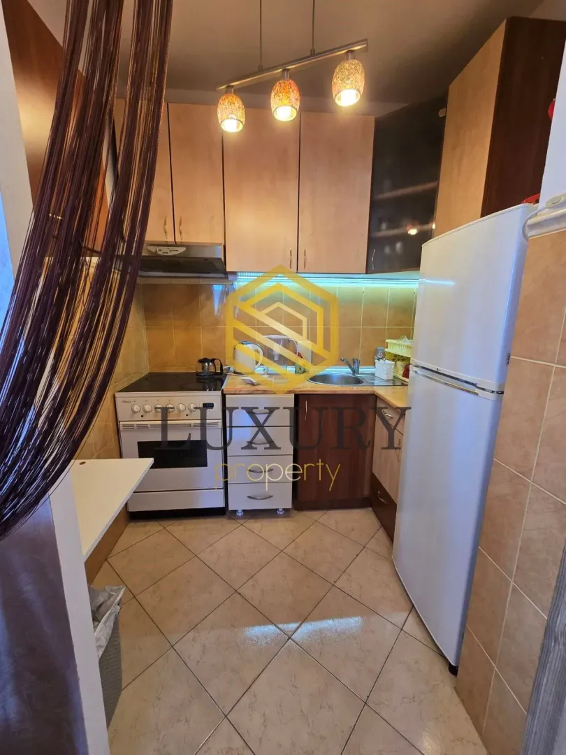 Smaller kitchen with cabinetry, stove, and refrigerator.