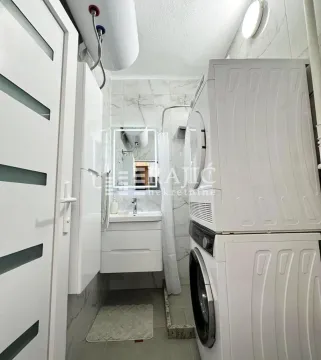 Small bathroom with a washing machine, shower cabin and washbasin. - image 10
