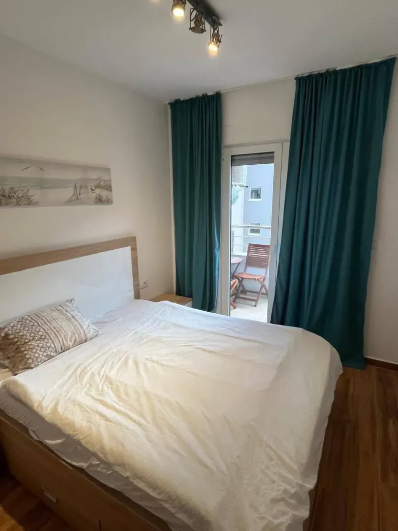 Furnished bedroom with a double bed and balcony access.