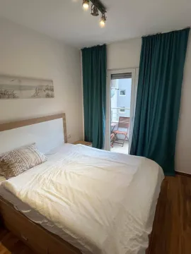 Furnished bedroom with a double bed and balcony access. - image 10