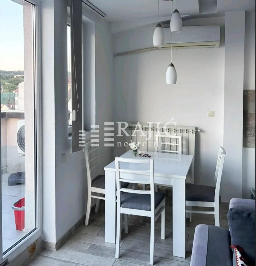 Dining area with a white table and chairs and access to the terrace.