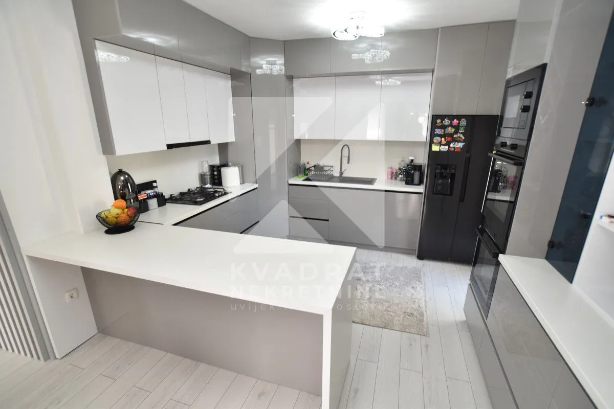 Modern kitchen with a breakfast bar and built-in appliances.