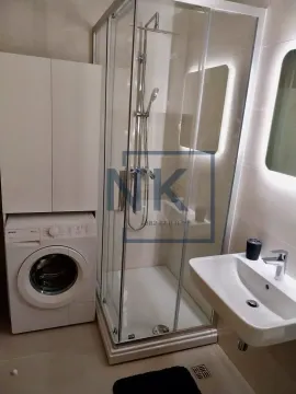 Modern bathroom with a shower cabin, washbasin, and washing machine. - image 10
