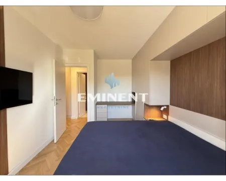 Furnished bedroom with a double bed, wardrobe, and a desk. - image 12
