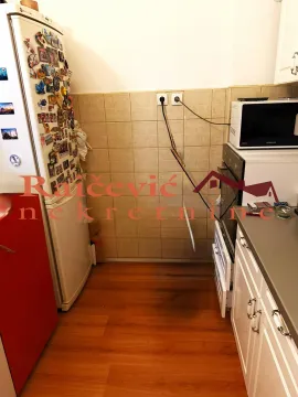 View of a section of the kitchen with a refrigerator, oven, and countertops. - image 6