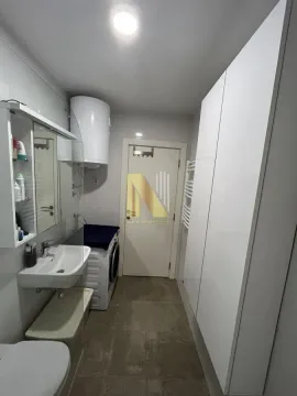 Moderno kupatilo sa umivaonikom, veš mašinom i ugradnim ormarima. - image 10