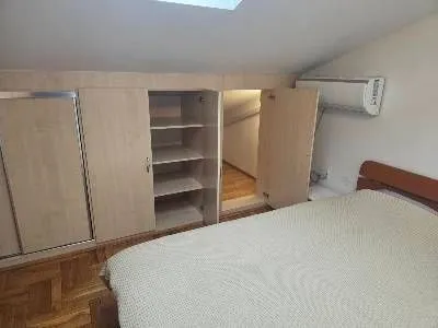 Bedroom with a double bed, built-in wardrobes, and a skylight.