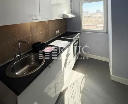 Small equipped kitchen with white cabinets and a window. - image 6