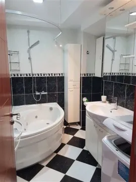 Svijetlo kupatilo sa đakuzi kadom, lavaboom i crno-bijelim pločicama. - image 7