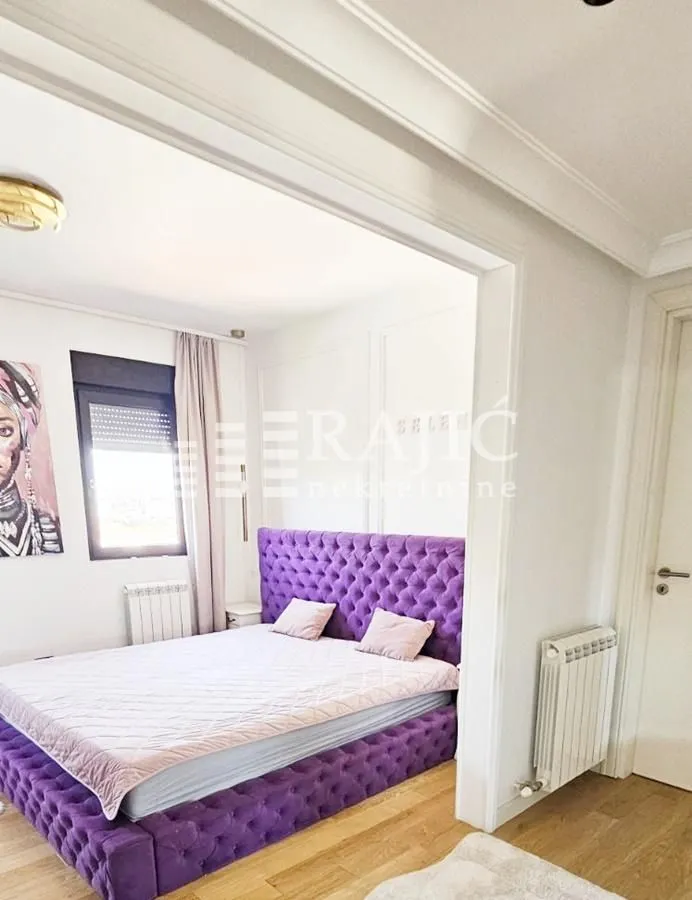 Furnished bedroom with a large purple bed.