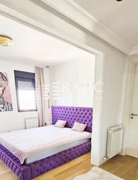 Furnished bedroom with a large purple bed. - image 3