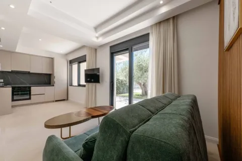 Living room connected to the kitchen, featuring a sofa and access to the yard. - image 2