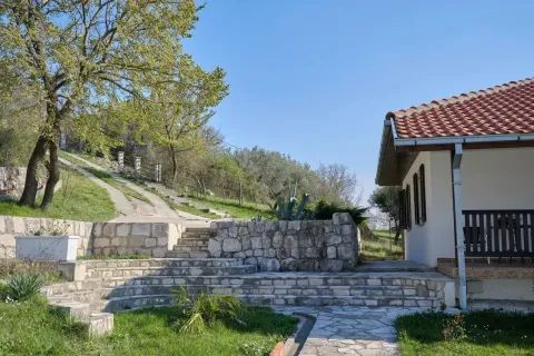 Exterior of the house with stone stairs and landscaped yard. - image 3