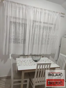 Trpezarijski sto sa belim stolicama ispred prozora sa zavesama. - image 5