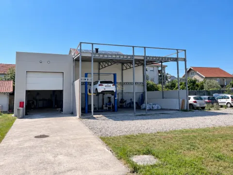 View of the exterior of a commercial building with an auto repair shop and an open section. - image 2