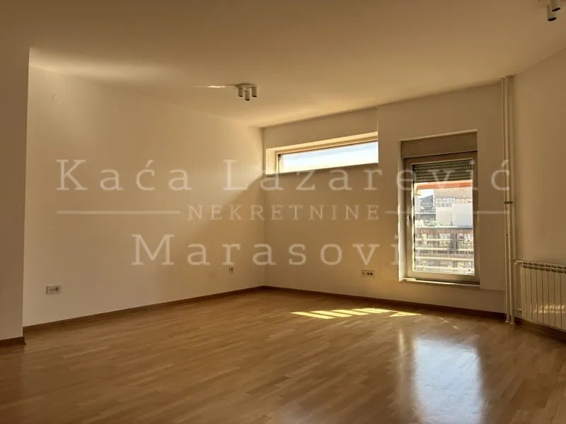 Empty room with wooden flooring and a window.