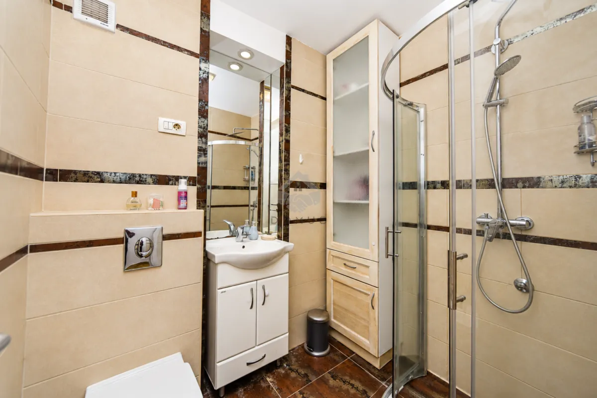 Bathroom equipped with a shower cabin, washbasin, and a built-in cabinet.