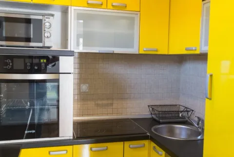 Kuhinja sa žutim elementima, ugradnom rernom, mikrotalasnom pećnicom i sudoperom. - image 8